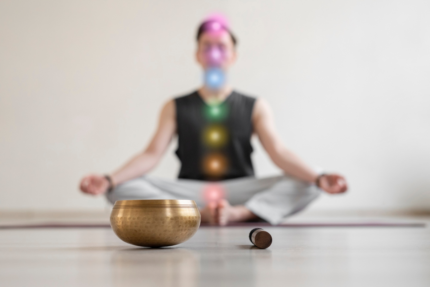 A person meditating with the seven chakra points glowing in color