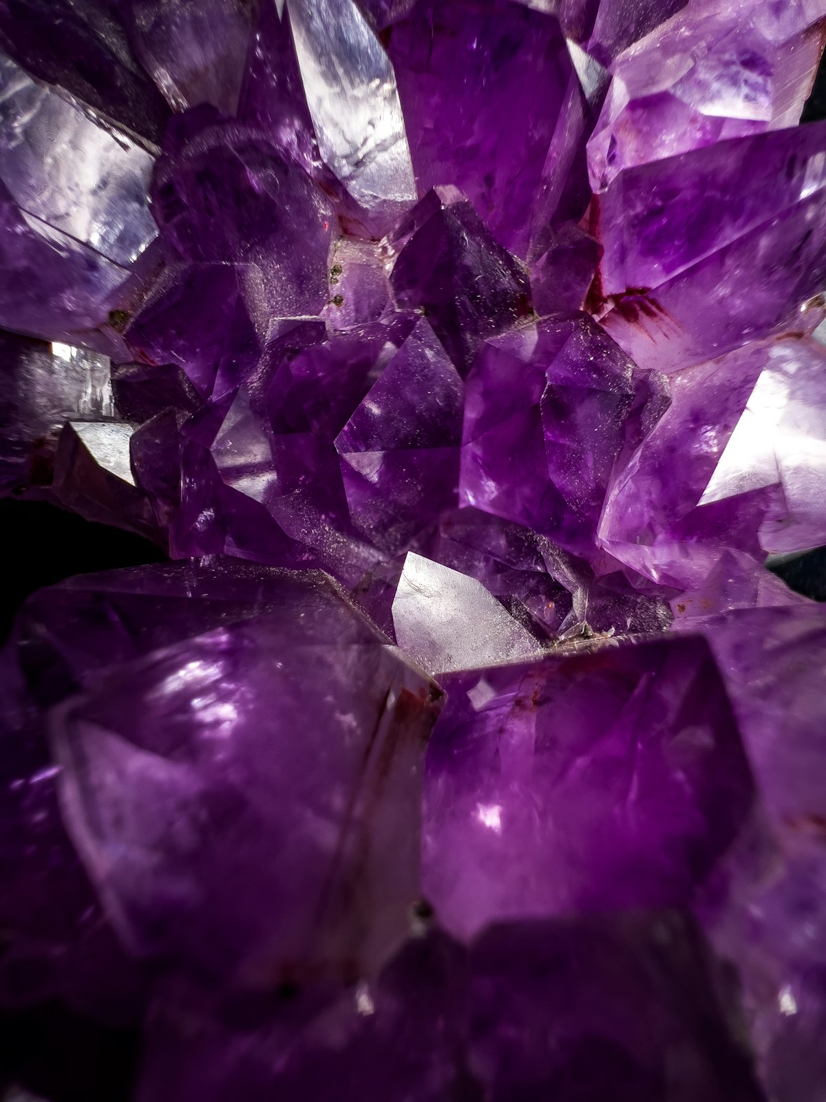 A glowing cluster of purple amethyst crystals