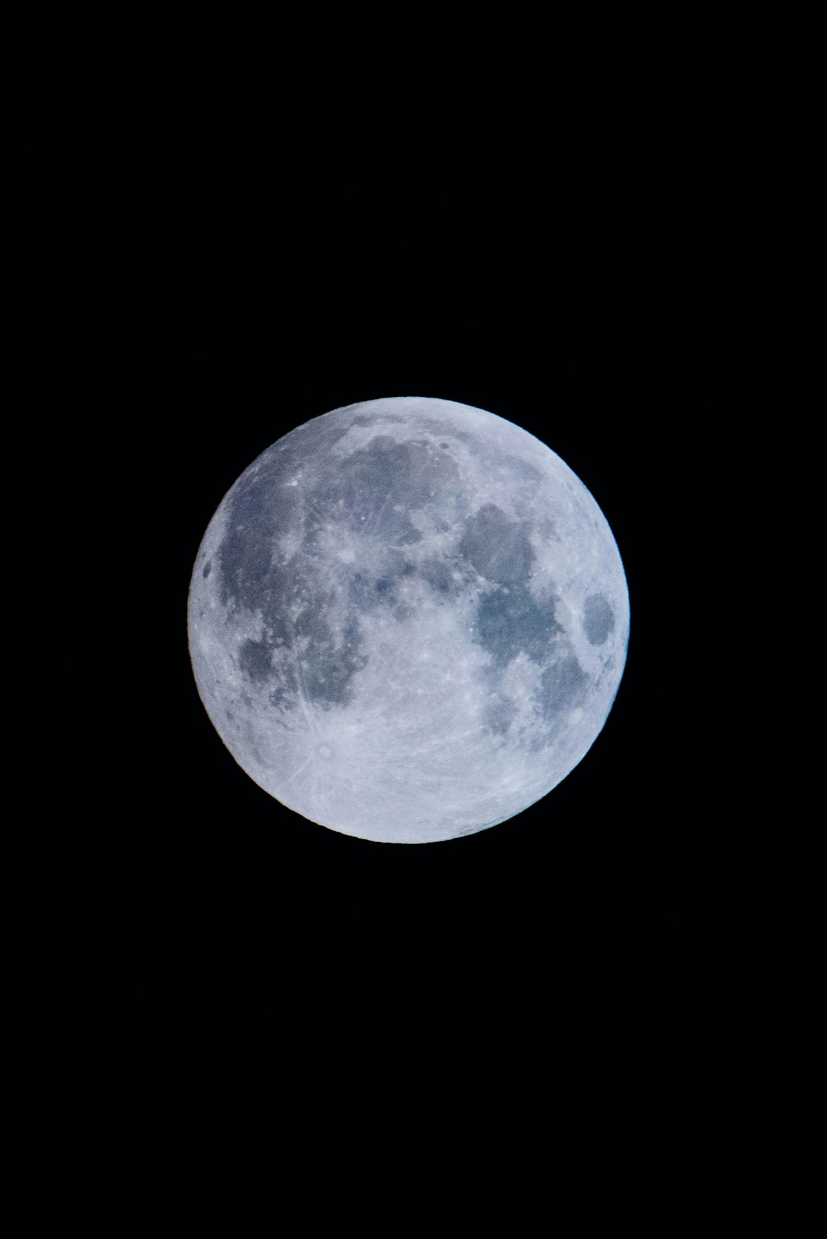 A blue full moon against a black night sky